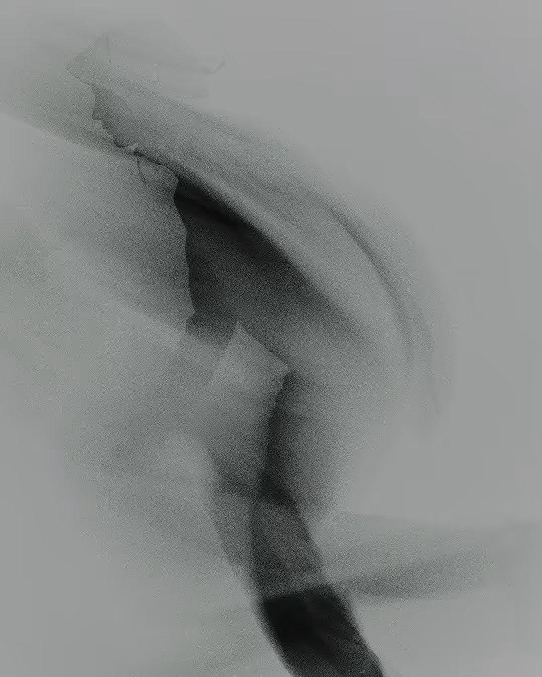 Blurred silhouette of a person bending forward with motion effects creating streaks around them.